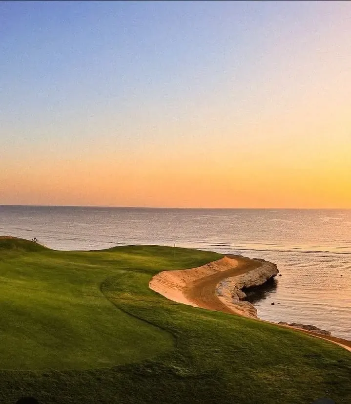 A Somabay golf green curving along the Red Sea at sunset